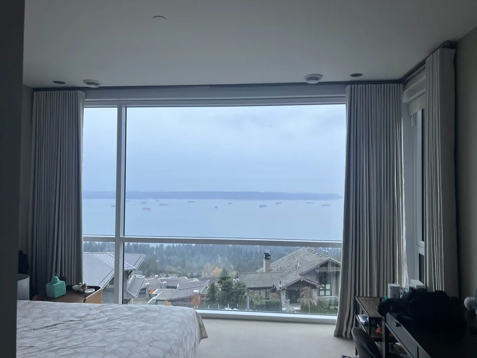 Curtains sit to either side of wide glazing, framing the view while keeping the opening visually clear