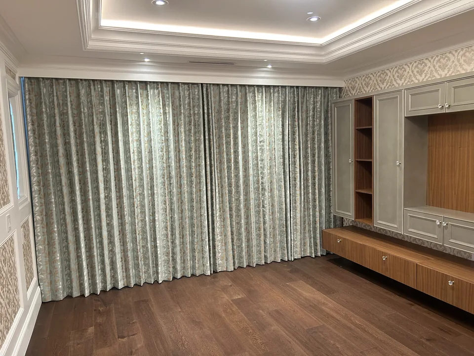 Patterned curtains span the wall beside built-in cabinetry