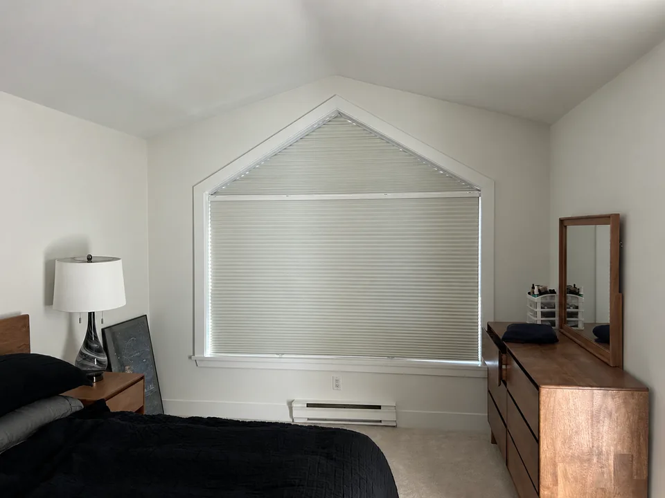A bedroom window combines a sloping upper section with a rectangular lower opening