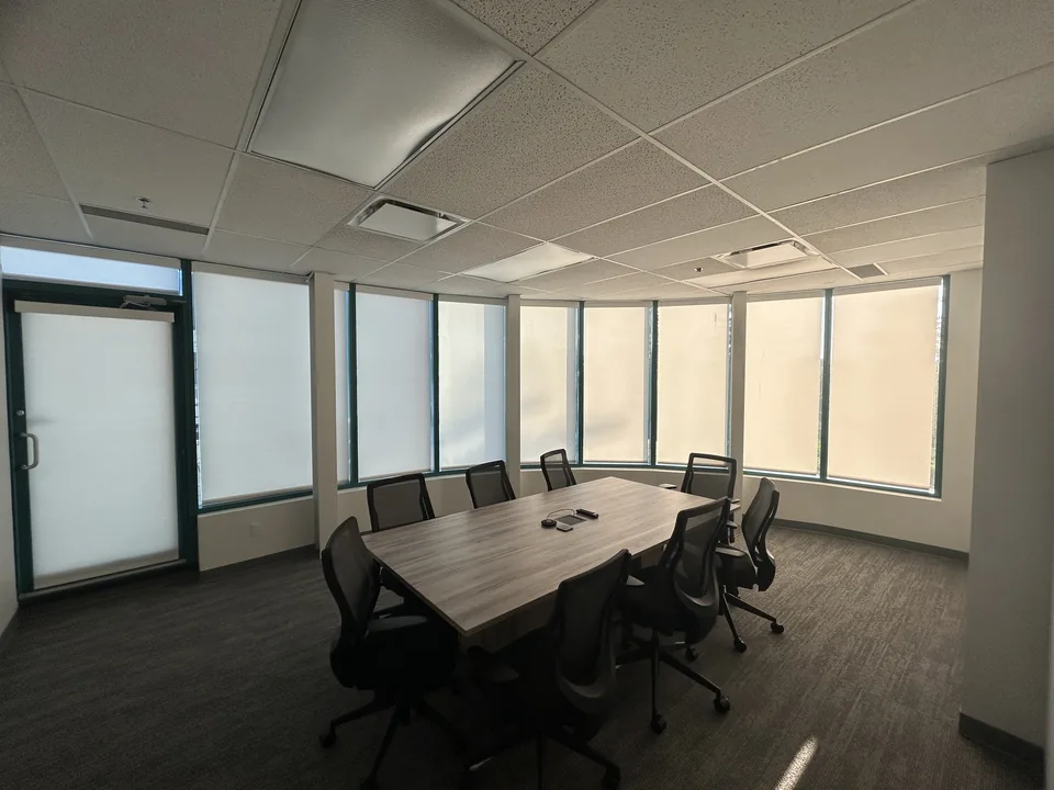 Individual roller shades follow a curved row of meeting-room windows