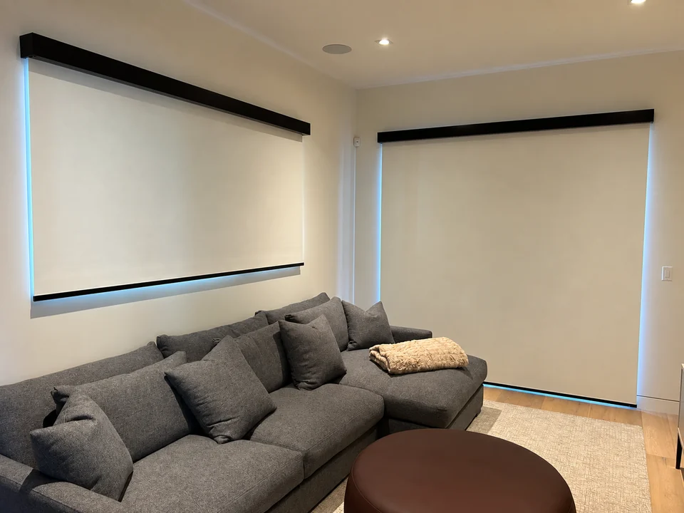 A coordinated set of roller shades frames a modern lounge