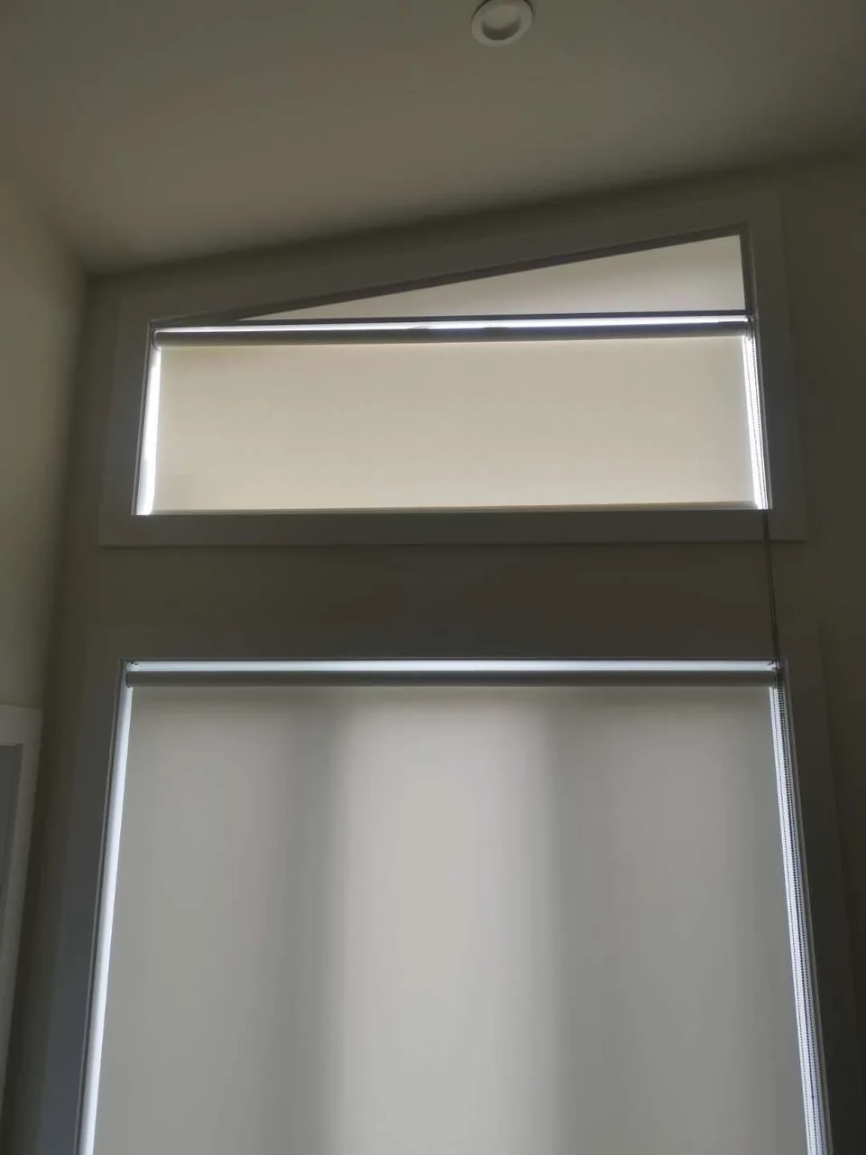 A sloping upper window paired with a rectangular window below