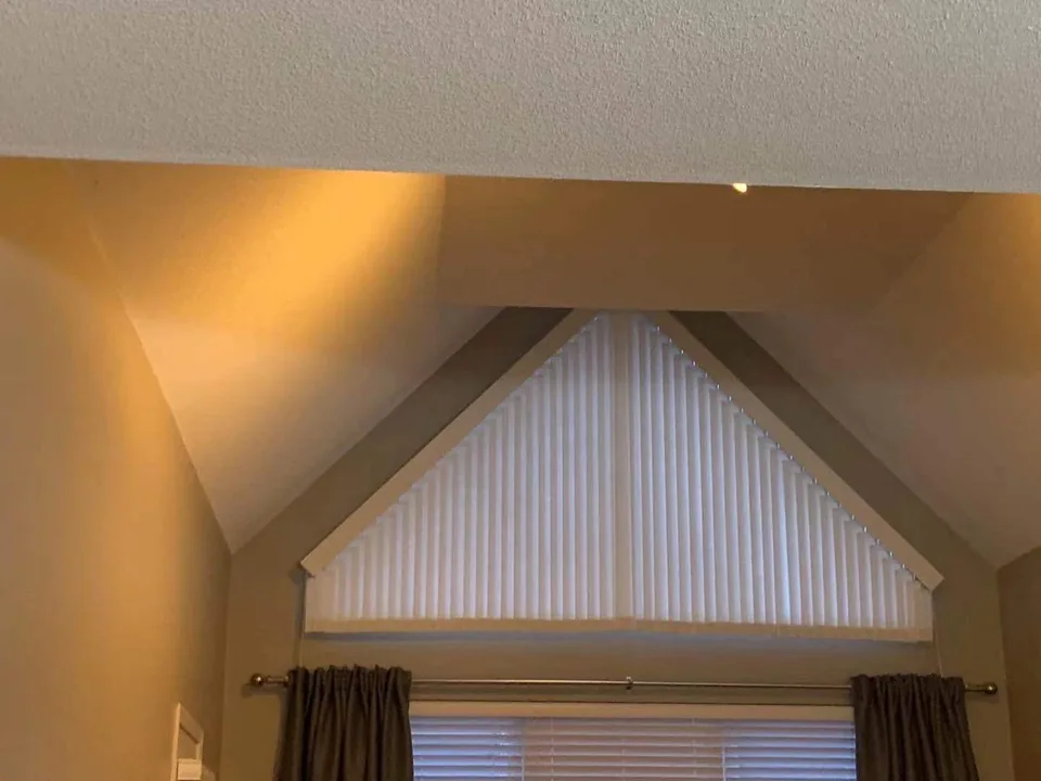 A window treatment fitted to the triangular opening above a rectangular window